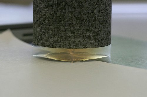 A cylindrical granite block resting on a thin, translucent slab of silica aerogel on a laboratory bench.