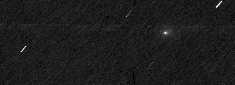 Three side-by-side monochrome frames of a dark star field streaked with motion, each with small arrows marking points of light, one of them the comet 3I/ATLAS.