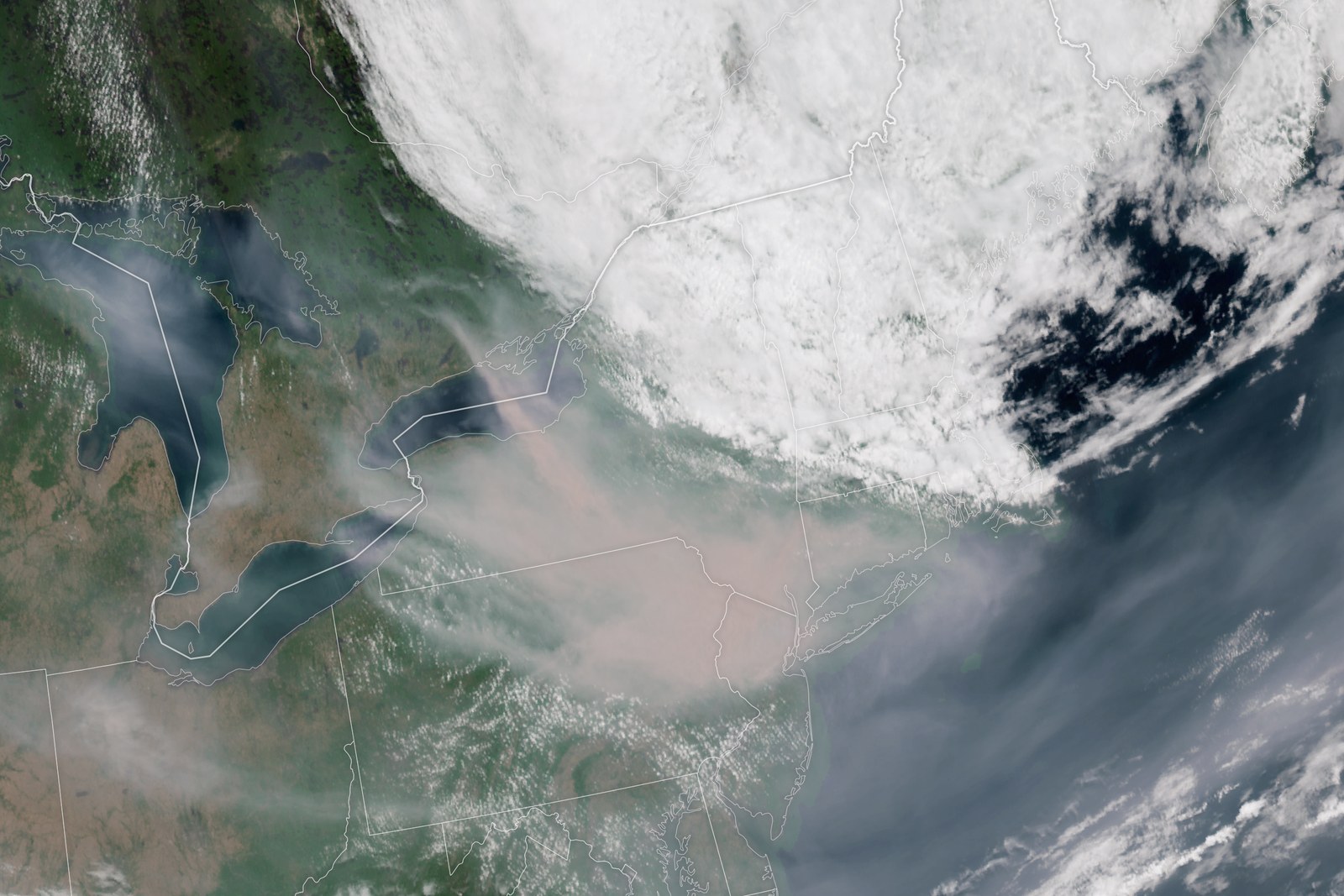 A satellite view of the northeastern United States with a broad tan plume of wildfire smoke spread across it.