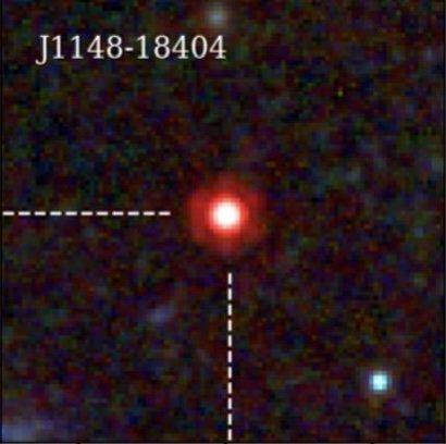 A small square telescope image of a bright compact red point of light in a dark, grainy field with a few faint specks around it.