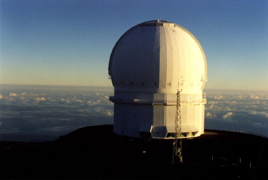 The white dome of the Canada-France-Hawaii Telescope standing above a layer of cloud on the summit of Mauna Kea.