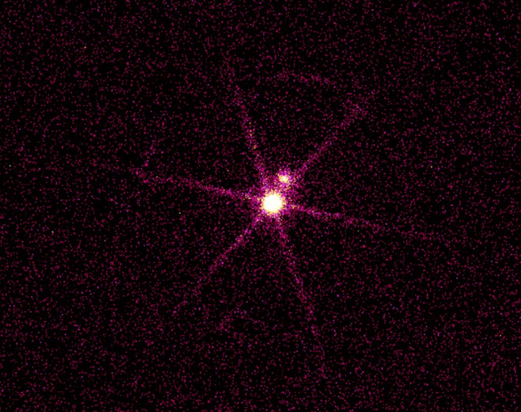 A Chandra X-ray image showing a bright point source with a fainter one just above it, against a speckled magenta field.