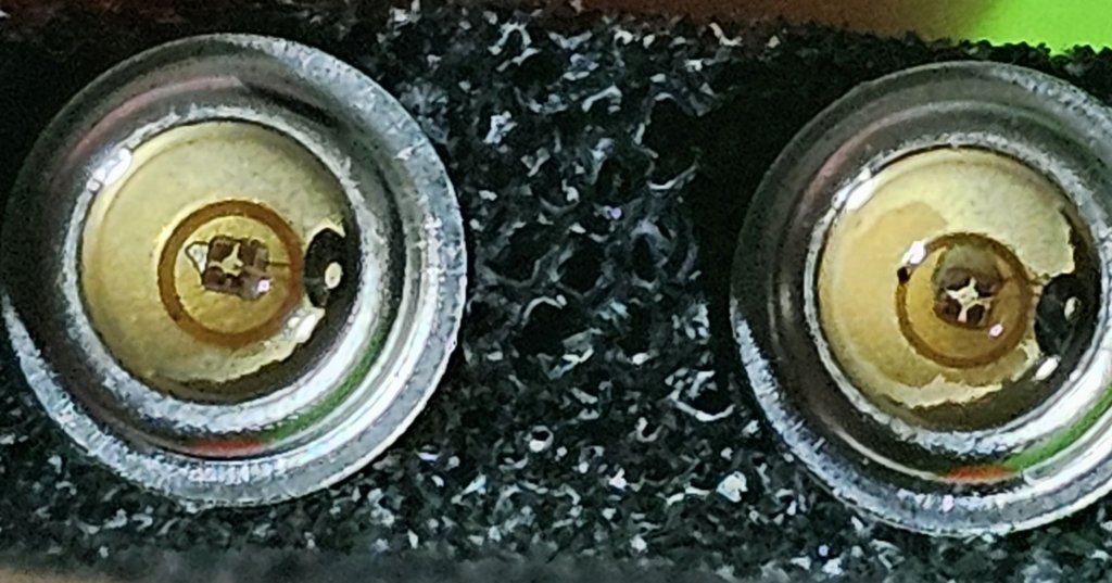 Close view of two semiconductor emitter dies sitting inside metal cans with glass windows.