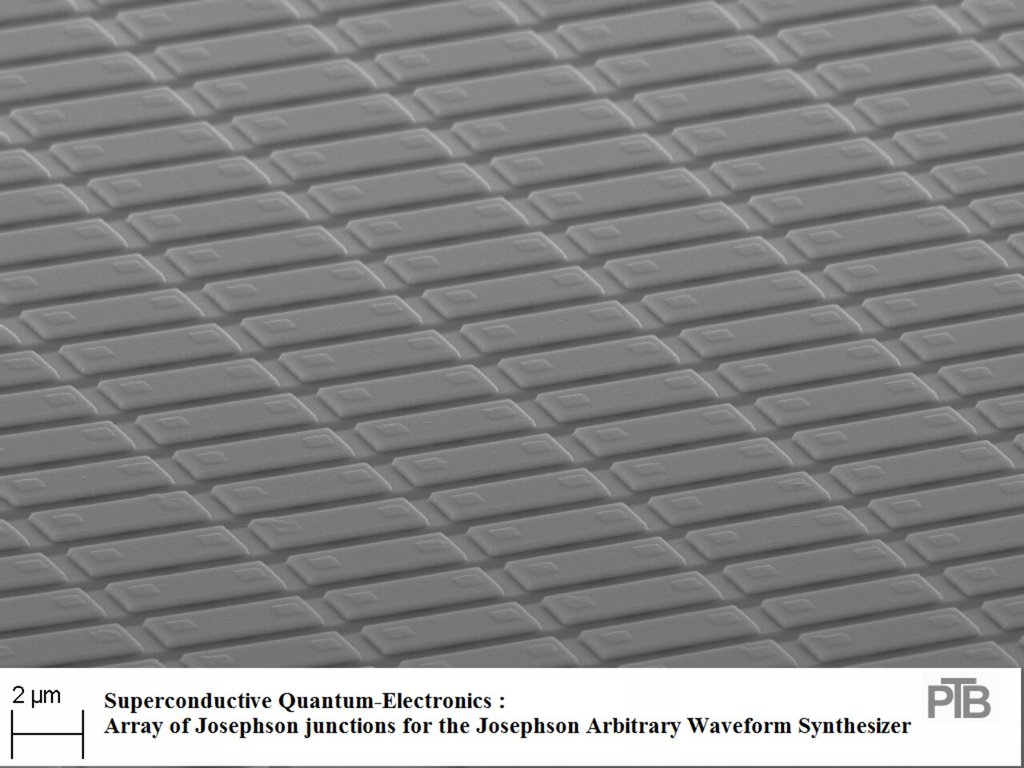 A dense grid of rectangular Josephson junctions on a chip surface, imaged in grayscale by an electron microscope, with a 2 micrometer scale bar.