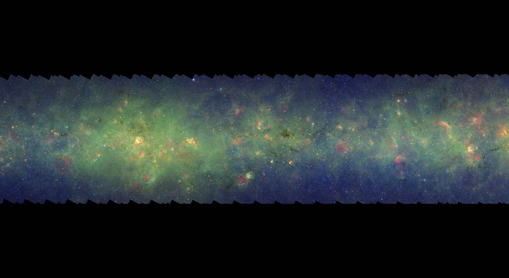A long horizontal strip of green and red infrared haze dense with stars, thickest along a narrow central line.