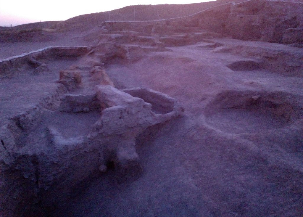 Excavated mud-brick wall foundations on an arid mound at dusk at Acemhoyuk in central Turkey.