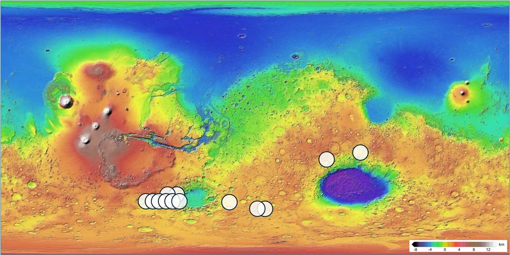 A global topographic map of Mars in rainbow colors, with white circles marking candidate impact craters and an elevation scale in kilometers at lower right.